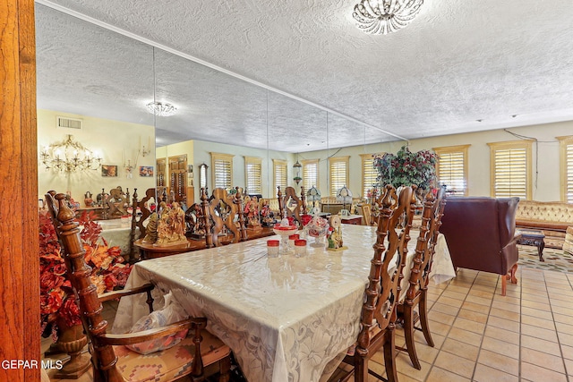 dining space featuring light tile patterned floors, visible vents, and a textured ceiling