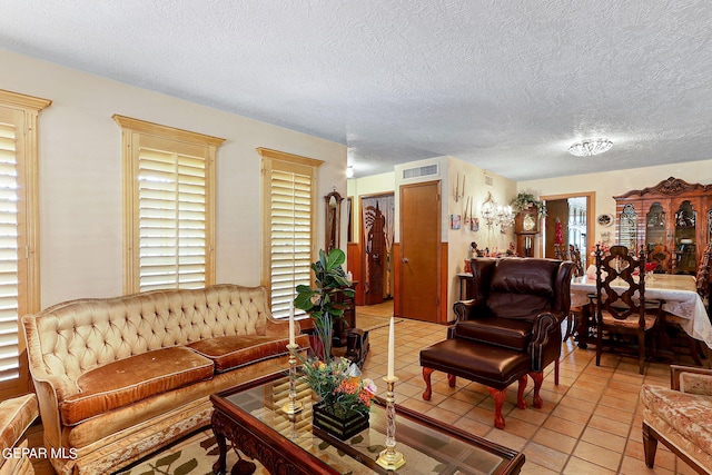 living room featuring light tile patterned floors, visible vents, and a textured ceiling