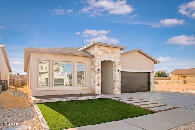 view of front of home with a front yard and a garage