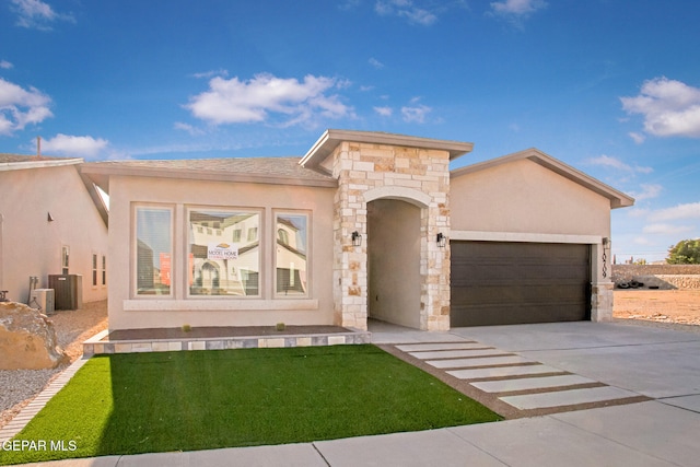 mediterranean / spanish-style house featuring a garage, central air condition unit, and a front lawn