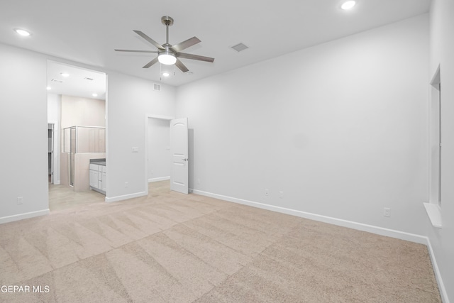 unfurnished bedroom featuring ensuite bath, ceiling fan, and light colored carpet