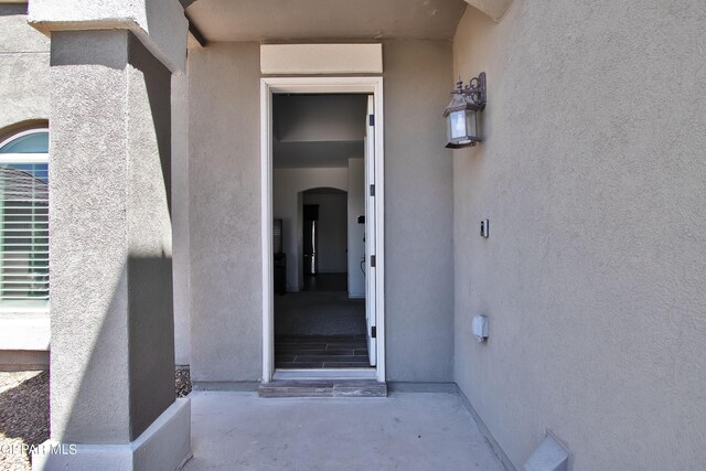 doorway to property featuring stucco siding