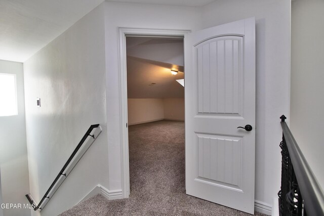 corridor with light carpet, baseboards, and an upstairs landing