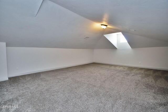 bonus room with vaulted ceiling, carpet floors, and baseboards