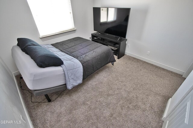 bedroom featuring carpet and baseboards