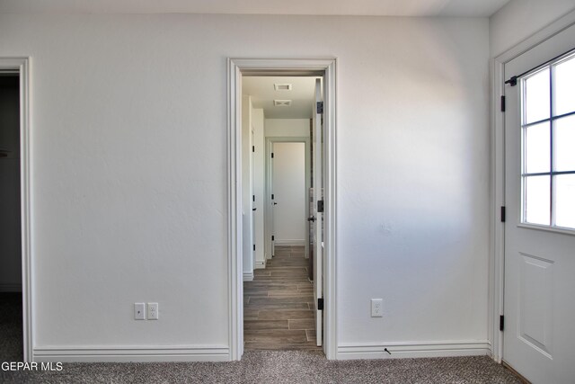 hall with visible vents, carpet, and a wealth of natural light