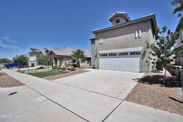 mediterranean / spanish-style home featuring a tile roof, concrete driveway, and stucco siding