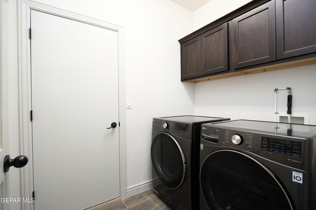 laundry room with wood finish floors, independent washer and dryer, cabinet space, and baseboards