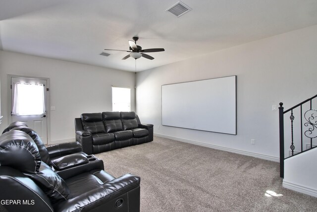 carpeted home theater room featuring ceiling fan, a wealth of natural light, and visible vents