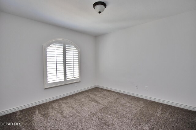 spare room featuring carpet floors and baseboards