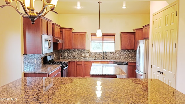 kitchen featuring sink, stainless steel appliances, light stone counters, and tasteful backsplash