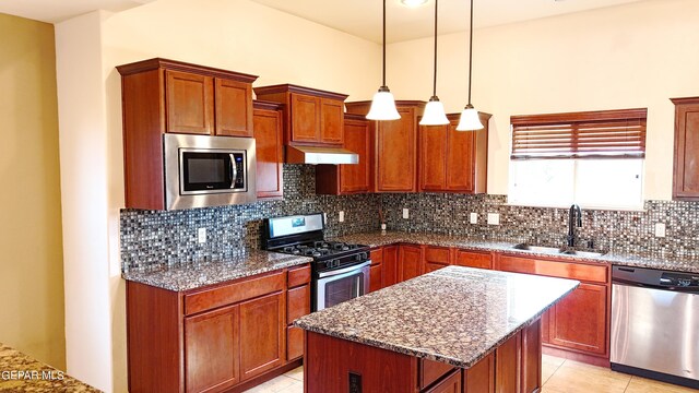 kitchen with sink, decorative backsplash, a center island, and stainless steel appliances