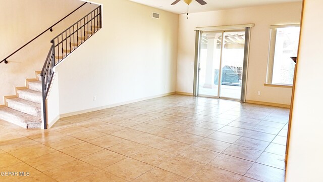 tiled empty room featuring ceiling fan