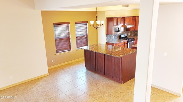 kitchen featuring appliances with stainless steel finishes, decorative light fixtures, backsplash, lofted ceiling, and light tile patterned floors