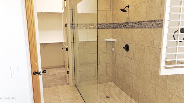 bathroom with a tile shower and tile patterned floors