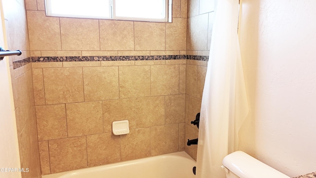 bathroom with shower / bath combo and toilet