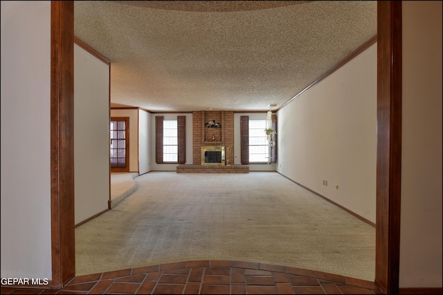 unfurnished living room featuring carpet, ornamental molding, a textured ceiling, and a brick fireplace