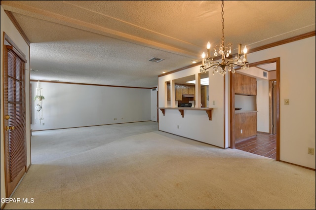 unfurnished living room featuring baseboards, visible vents, ornamental molding, carpet, and a textured ceiling