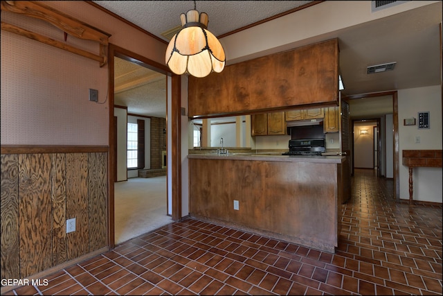 kitchen with visible vents, a peninsula, a textured ceiling, black range, and under cabinet range hood