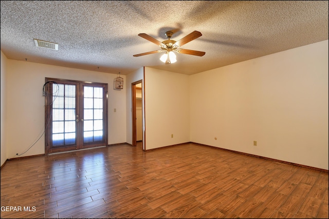 spare room featuring a textured ceiling, visible vents, wood finished floors, and french doors