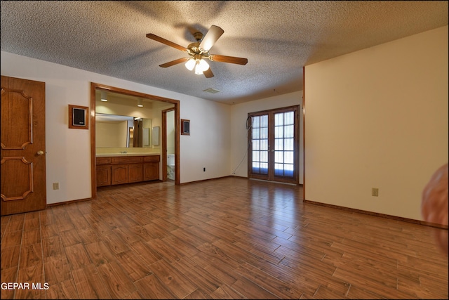 interior space featuring a textured ceiling, ceiling fan, wood finished floors, and baseboards