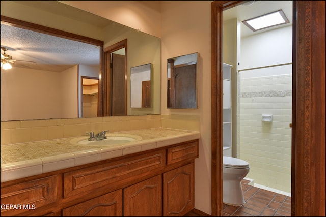 full bathroom with toilet, tile patterned flooring, walk in shower, a textured ceiling, and vanity