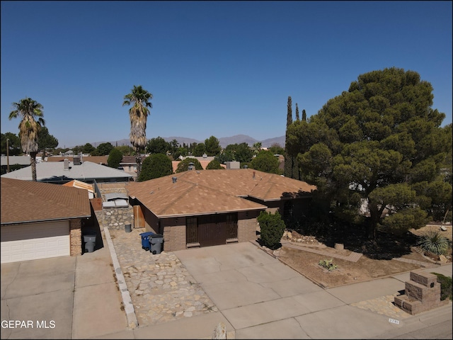 view of front of property with driveway, a mountain view, and brick siding