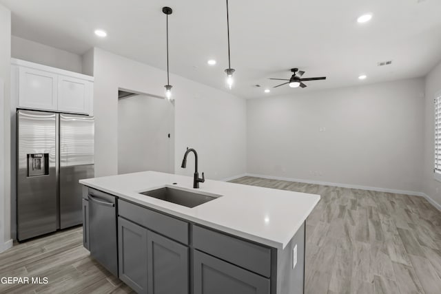 kitchen featuring ceiling fan, light wood-type flooring, a kitchen island with sink, appliances with stainless steel finishes, and sink