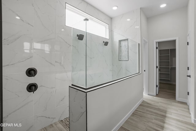 bathroom with tiled shower and hardwood / wood-style flooring