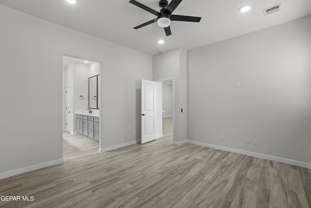 empty room featuring ceiling fan, light wood-type flooring, and sink