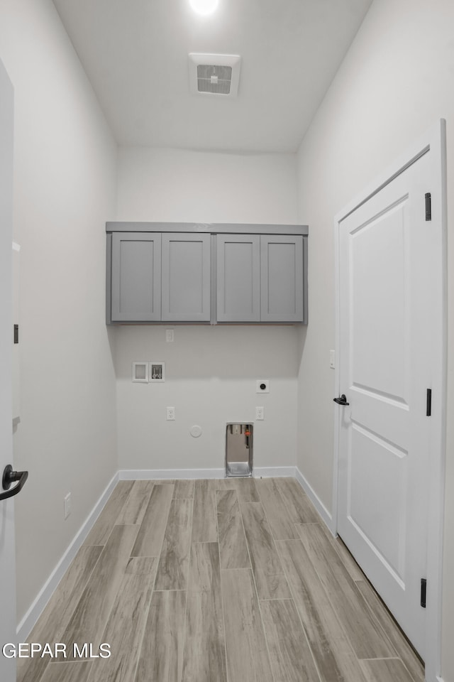 washroom featuring light hardwood / wood-style flooring, hookup for a gas dryer, hookup for a washing machine, cabinets, and electric dryer hookup