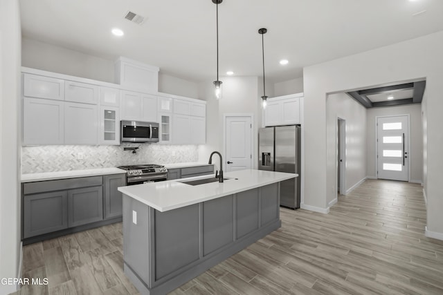 kitchen featuring a kitchen island with sink, a sink, visible vents, light countertops, and appliances with stainless steel finishes