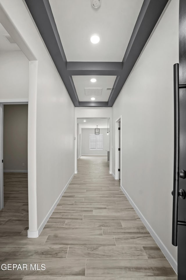 hallway with light wood finished floors, baseboards, and recessed lighting