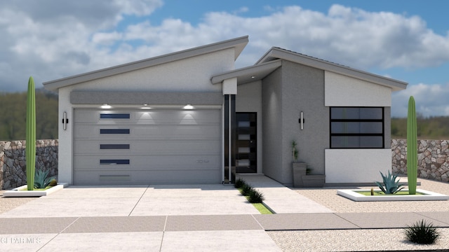 contemporary home with a garage, driveway, and stucco siding