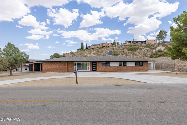 ranch-style house with concrete driveway and brick siding