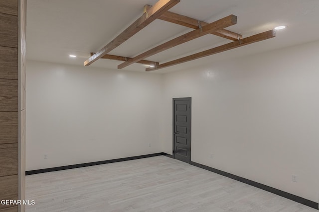 spare room featuring recessed lighting, beamed ceiling, baseboards, and light wood-style floors