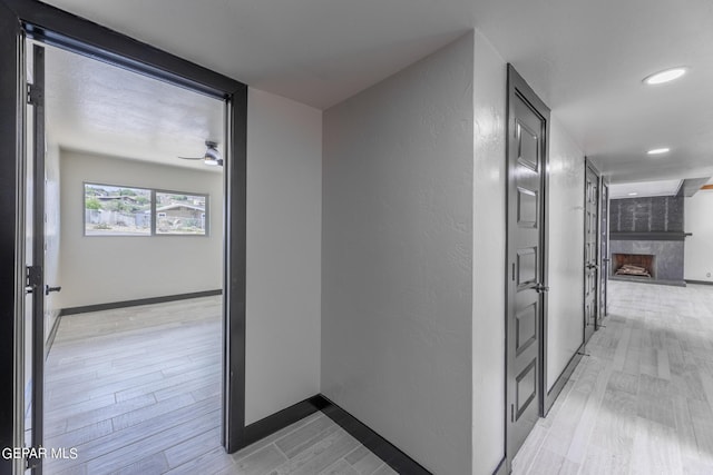 corridor with recessed lighting, baseboards, and light wood finished floors