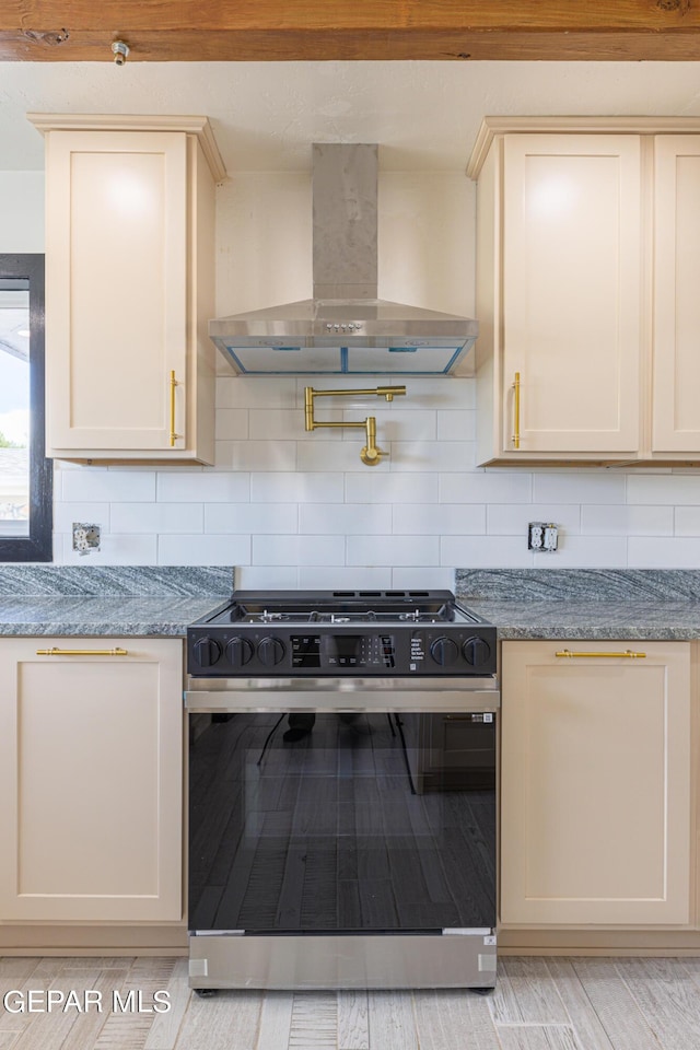 kitchen with range with gas cooktop, wall chimney range hood, and tasteful backsplash