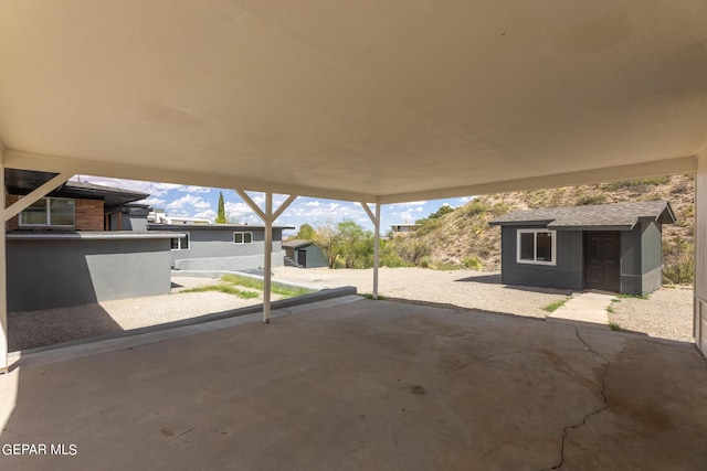 view of patio with an outdoor structure and a shed