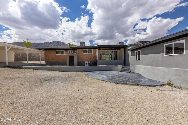 rear view of house with a patio area and a mountain view