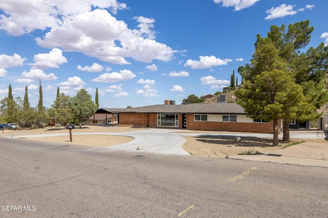 ranch-style house with brick siding and curved driveway