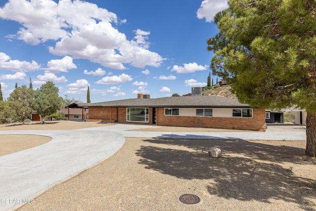 ranch-style home with brick siding and curved driveway