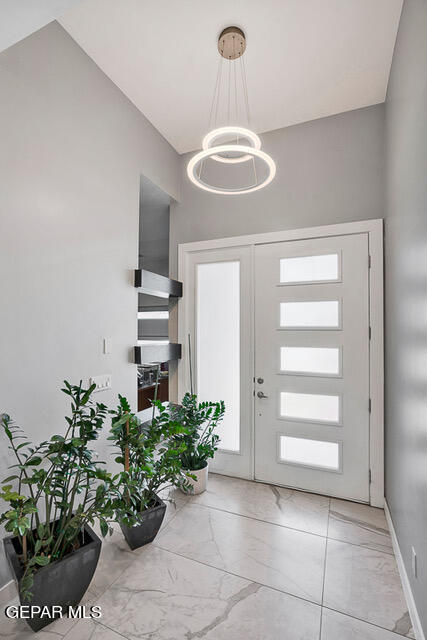 foyer entrance with a notable chandelier and light tile patterned flooring