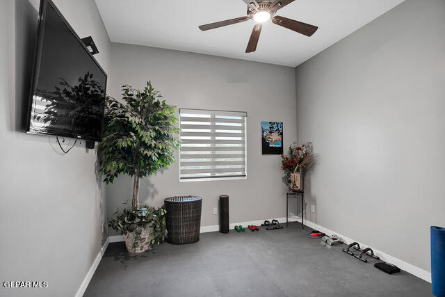 interior space featuring ceiling fan and concrete floors