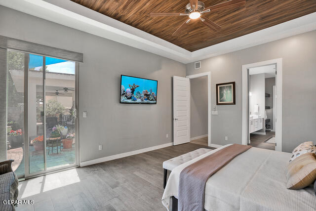 bedroom featuring ceiling fan, wood ceiling, wood-type flooring, ensuite bath, and access to exterior