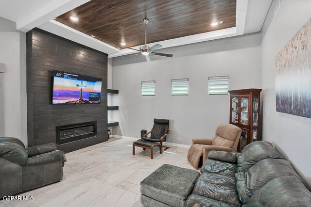 tiled living room with plenty of natural light, ceiling fan, and wooden ceiling