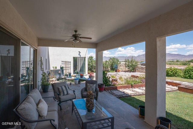 sunroom / solarium featuring ceiling fan and a mountain view