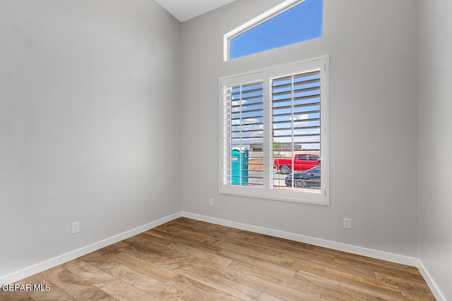 spare room with a wealth of natural light and light hardwood / wood-style flooring