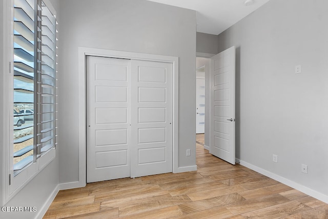 unfurnished bedroom with a closet and light hardwood / wood-style flooring