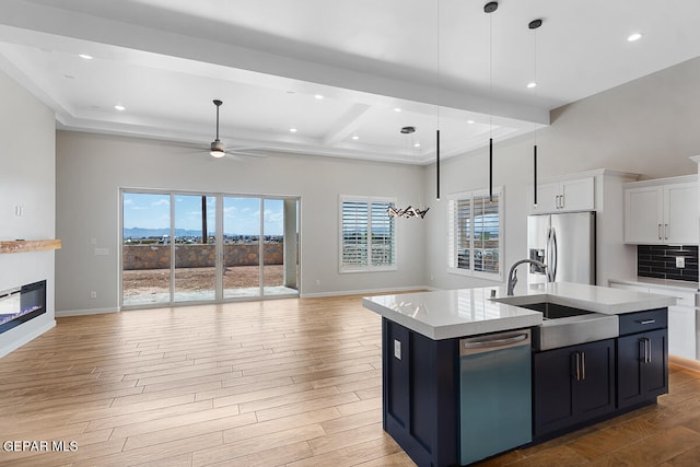 kitchen featuring stainless steel appliances, a center island with sink, and a healthy amount of sunlight